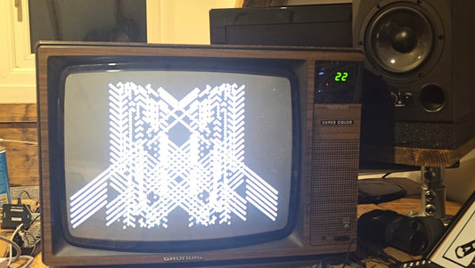 Abstract black-and-white video synthesis pattern displayed on a vintage CRT television